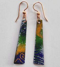 the earrings are made out of glass and have gold earwires with colorful designs on them