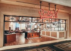 the inside of a restaurant with wooden flooring and large windows that read buddy's resturant