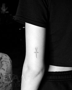 a person with a small tattoo on their left arm and the other arm behind her