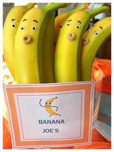 bananas with faces drawn on them sitting in a bowl next to a sign that says banana joe's