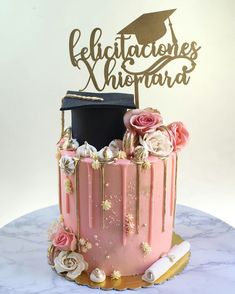 a graduation cake decorated with pink frosting and gold decorations, topped with a black hat