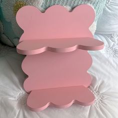 a pink teddy bear shaped shelf sitting on top of a bed