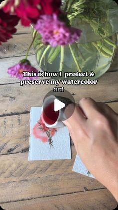 someone is painting flowers with watercolors on paper and then they are pouring them into a vase