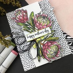 a close up of a card with flowers on it and some markers next to it