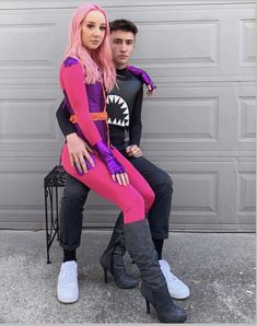 a man and woman dressed up in costume sitting on a bench next to a garage door