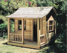 a small wooden house in the middle of some grass