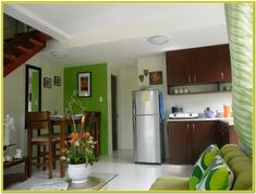 a kitchen and living room with stairs leading up to the upper floor, in an apartment