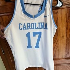 a white and blue basketball jersey hanging on a rack