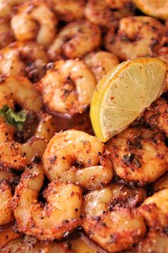 closeup of cooked shrimp with lemon wedge and garnish