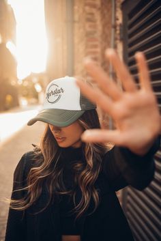 a woman wearing a green and white trucker hat