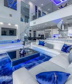 a living room filled with white furniture and blue lighting