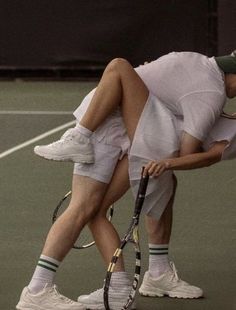 two tennis players are bending over on the court to hug each other's butts