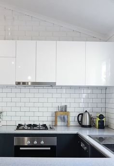 a kitchen with white cabinets and black counter tops is seen in this image from the front view