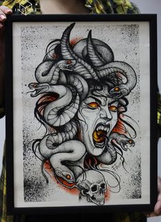 a woman holding up a framed drawing with a snake on it's head and a skull in her hand