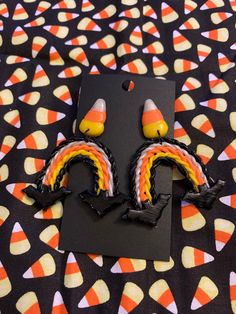 two candy corn ear clips on top of a black card