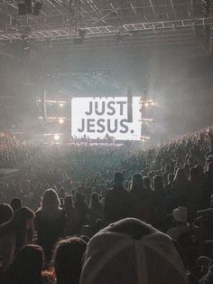 a large crowd at a concert with the words just jesus on it