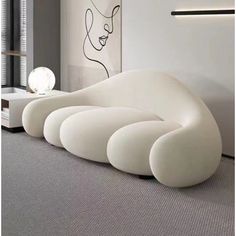 a white couch sitting on top of a carpeted floor