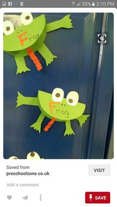 two paper frog puppets are hanging on a door with the word frog spelled in large letters