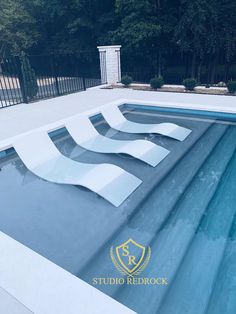 an empty swimming pool in the middle of a yard with trees and bushes behind it