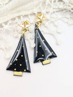 A pair of sleek modern minimalist Christmas tree earrings handmade with polymer clay. The trees are black with shimmering gold dots and hang from shiny gold star studs that are stainless steel. These Scandi inspired trees have a high gloss making them sophisticated and classy. The perfect addition to your Christmas outfit! Care Advice: ✿ Take care not to drop polymer clay jewellery, as it may break just like any other clay or glass jewellery. ✿ To clean polymer clay jewellery, wipe it off with a Clay Earrings Holiday, Polymer Clay Christmas Jewelry, Christmas Tree Polymer Clay Earrings, Polymer Clay Winter Earrings, Polymer Clay Christmas Tree Earrings, Christmas Earrings Clay, Winter Polymer Clay Earrings, Christmas Earrings Polymer Clay, Polymer Clay Christmas Earrings