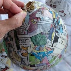 a hand holding an ornament decorated with comics