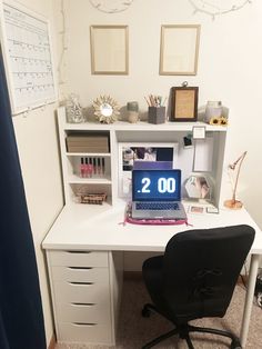 a desk with a laptop computer on top of it next to a chair and other items