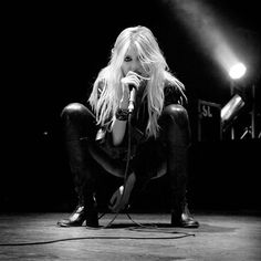 black and white photograph of a woman sitting on the floor with microphone in her hand