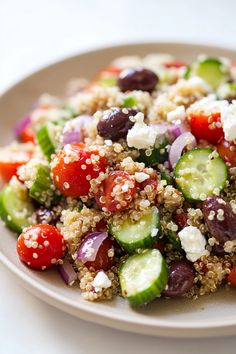 a salad with cucumbers, tomatoes, olives and feta cheese on it