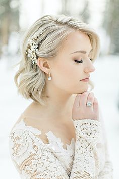 a woman with blonde hair wearing a white dress and holding her hand to her face