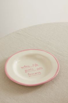 a pink and white plate with writing on it