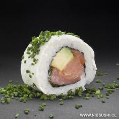 there is a sushi roll that has been cut in half and sprinkled with green onions