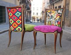 two colorful chairs sitting on the street next to each other