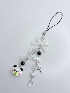 a key chain with charms attached to it on a white surface and a panda bear charm hanging from the front