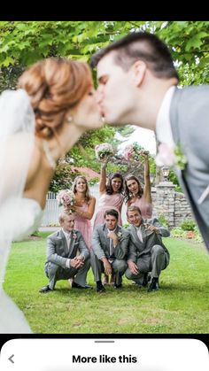 a bride and groom kissing in front of their wedding party