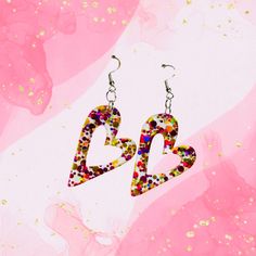 These heart earrings are made of confetti glitter acrylic and measure 1.6 inches. Multicolor Heart Earrings With Charm For Valentine's Day, Multicolor Heart Charm Earrings For Valentine's Day, Multicolor Heart Charm Earrings For Parties, Multicolor Earrings For Valentine's Day Party, Fun Multicolor Earrings For Valentine's Day, Valentine's Day Multicolor Heart Earrings For Pierced Ears, Multicolor Fun Heart Earrings, Valentine's Day Multicolor Dangle Heart Earrings, Multicolor Party Earrings For Valentine's Day