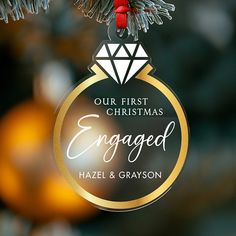 an ornament hanging from a christmas tree with the words engaged and a diamond on it