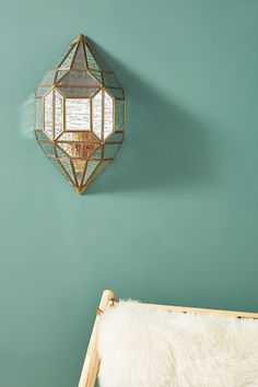 a gold mirror hanging on the wall next to a white sheepskin rug and wooden bed frame