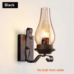 a light that is on the wall next to a black candle holder with a bulb in it