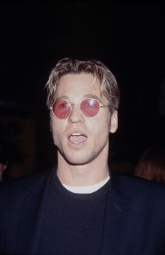 a man wearing red sunglasses and a black shirt