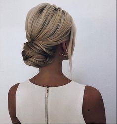 the back of a woman's head with blonde hair styled into a low bun