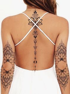 the back of a woman's body with tattoos on her upper and lower arm