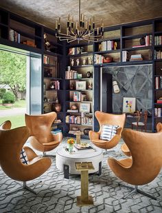 a living room filled with lots of furniture and a chandelier hanging from the ceiling