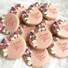 a bunch of cookies that are decorated with flowers and words on the top one is happy new year