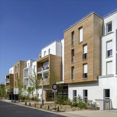 a row of multi - story apartment buildings next to a street