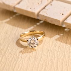 a diamond ring sitting on top of a piece of paper next to a block of wood