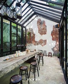 an outdoor dining area with tables and stools in front of the glass walls that have been torn down