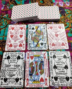 four playing cards are laid out on a colorful table cloth, with the same design