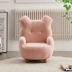 a teddy bear chair sitting on top of a rug in front of a radiator