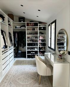 a walk in closet filled with lots of white furniture