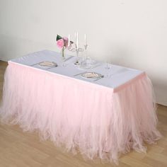 a pink tulle table skirt with two place settings